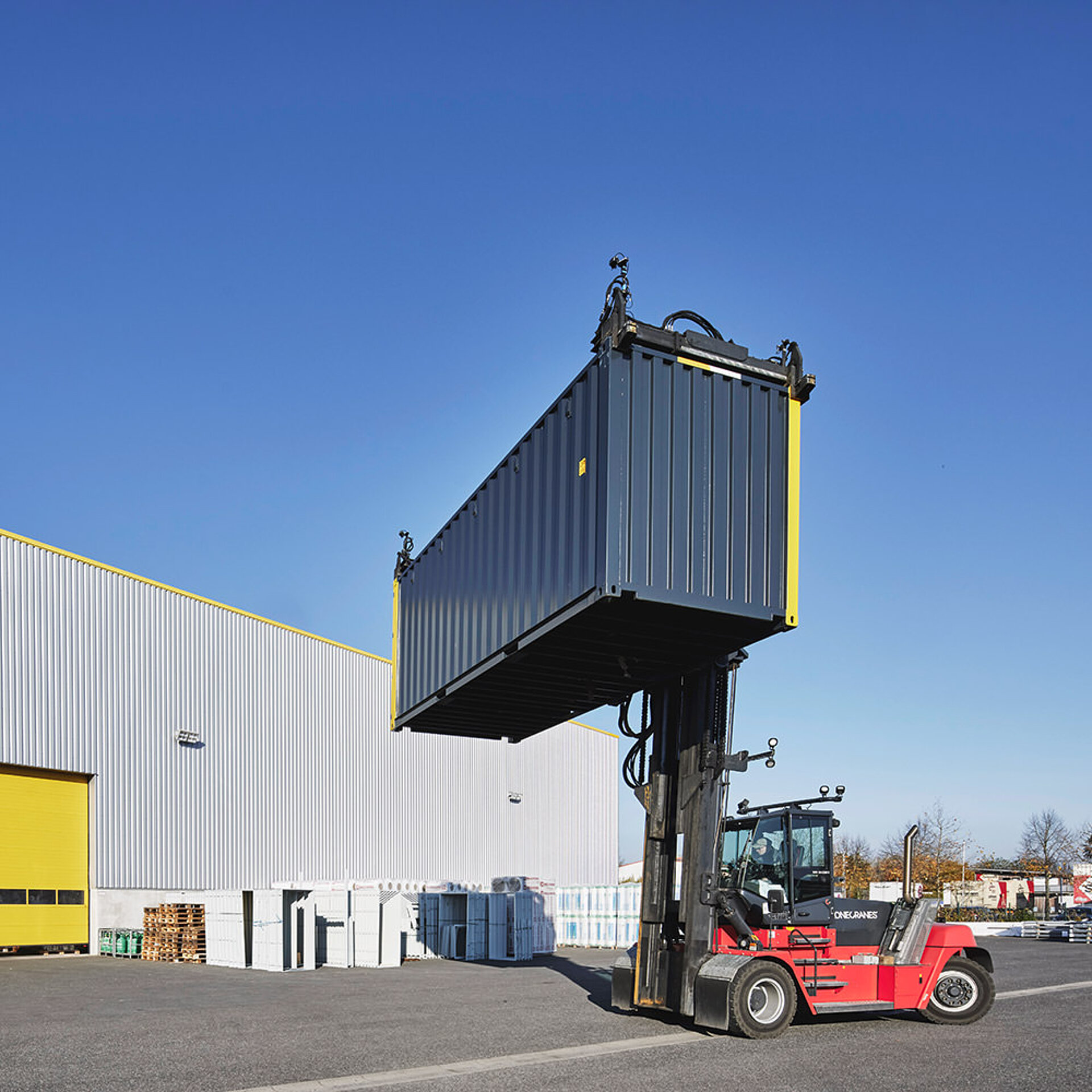 Gabelstapler auf Firmengelände mit Container